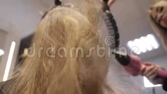 在理发店里用吹风机烘干头发飞进照相机视频的预览图