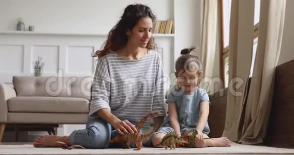 快乐妈妈和小女儿玩恐龙坐在地板上视频的预览图