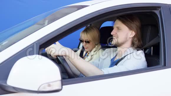 男司机和女乘客在坐白色汽车时在蓝色屏幕背景下争吵布鲁内特曼视频的预览图