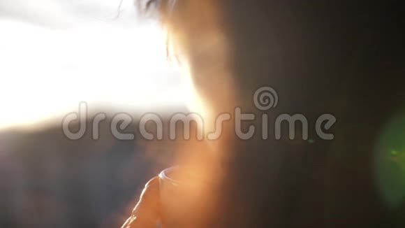 女人在阳台上喝咖啡欣赏日落慢动作视频的预览图