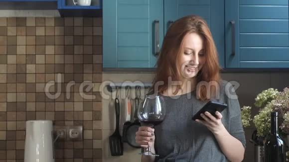 女孩喜欢喝杯子里的酒和发短信的电话视频的预览图