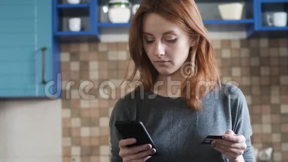 红发美女正用信用卡在网上购物视频的预览图