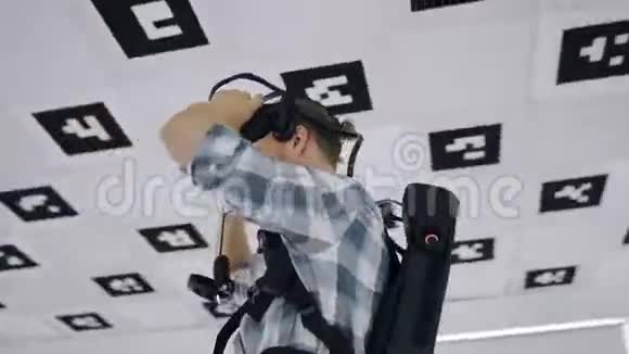 特写追踪弧360度延时镜头一个年轻人拿着虚拟现实耳机上下并瞄准视频的预览图