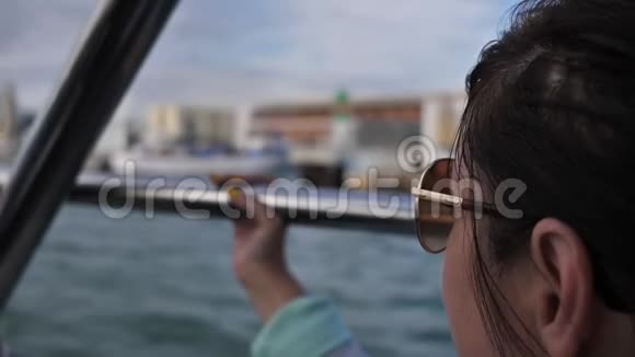 戴墨镜的旅行妇女在船上漂浮环顾四周特写视频的预览图