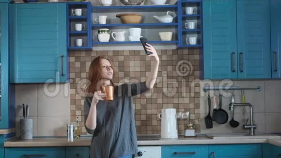 拍照自拍智能手机女孩在现代厨房喝早咖啡视频的预览图