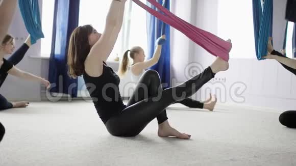 课堂上的女性做空中瑜伽吊床接近臀部高度动作通常至少有一英尺视频的预览图