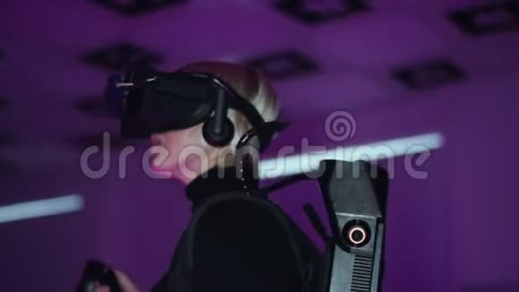 一位成年女性在虚拟现实耳机中观看视频的特写镜头手中拿着控制器空玩室视频的预览图