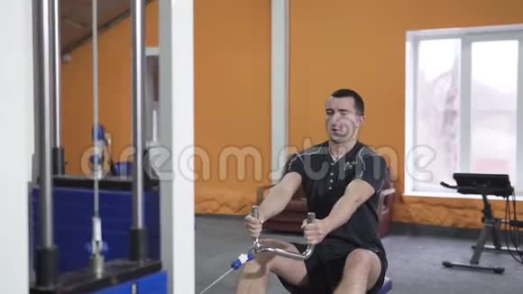 健身馆里的盖伊健美运动员用一根棒子收紧改善三头肌视频的预览图