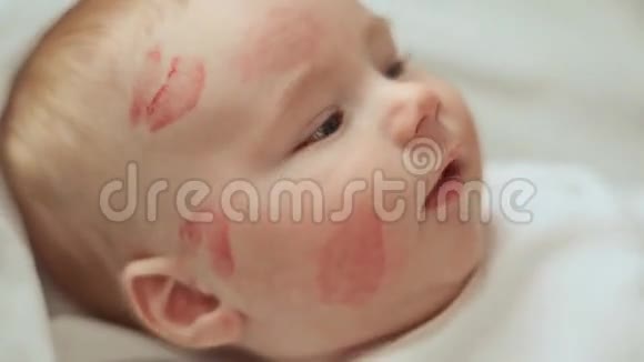妈妈擦去婴儿脸颊上吻痕迹孩子微笑旋转视频的预览图