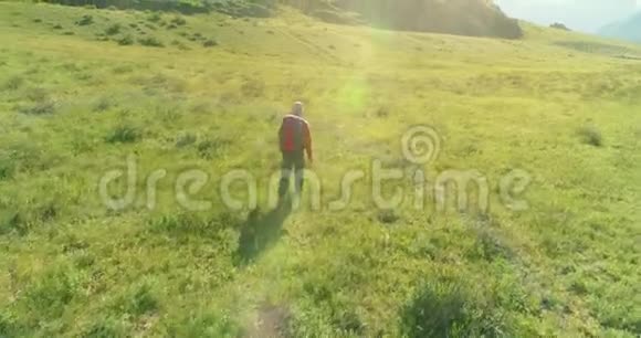 飞行背包徒步旅行游客走过青山野夏日的乡村山谷视频的预览图