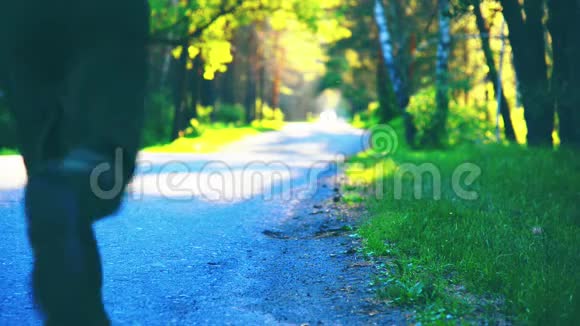 运动男在柏油路跑步乡村城市公园绿树森林和地平线上的阳光视频的预览图