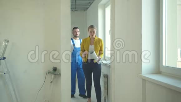 手里拿着计划的女人向修理工展示公寓视频的预览图