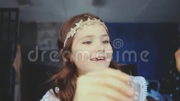 一个小女孩坐在镜子前欣赏自己视频的预览图