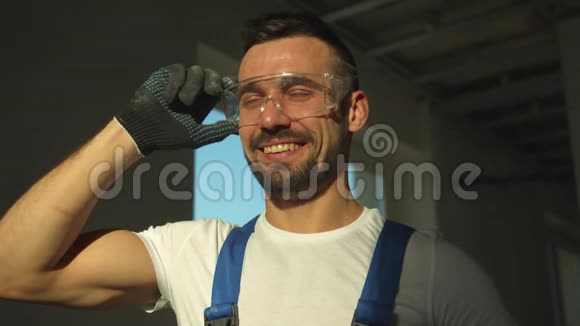 微笑建筑工人站着戴上防护眼镜慢动作视频的预览图