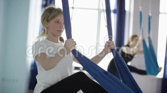 女性瑜伽课的腿部拉伸练习金发美女集体练习健康生活方式视频的预览图