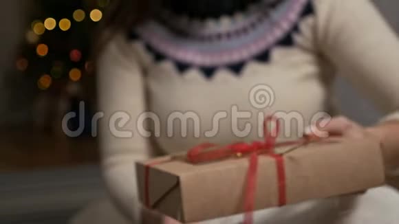 女人拿着圣诞礼物里面有姜饼饼干小男人吃饼干视频的预览图