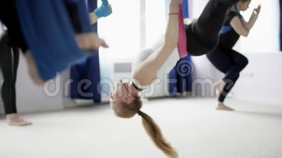 空中瑜伽工作室的健身活动女性在室内用4K镜头练习吊床视频的预览图