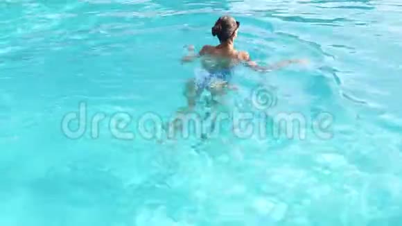 在豪华酒店水疗中心美丽的女人在游泳池后游视频的预览图