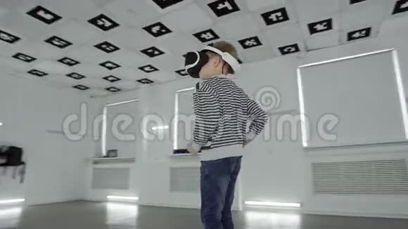 跟踪弧360度拍摄的一个小男孩在虚拟现实中打东西戴着一个大空白的耳机视频的预览图