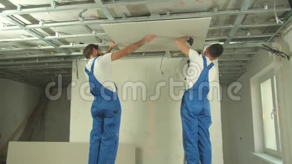两个穿制服的建筑工人把面板安装在天花板上视频的预览图