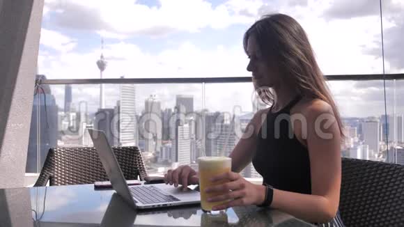 自信的商务女性正在商务中心露台上的笔记本电脑上工作时髦漂亮的女人做一个视频的预览图