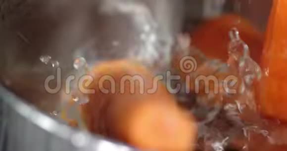 一碗水中的新鲜胡萝卜掉落视频的预览图