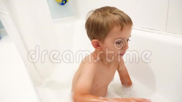 4k慢动作视频可爱的小男孩洗澡用肥皂泡沫和玩视频的预览图