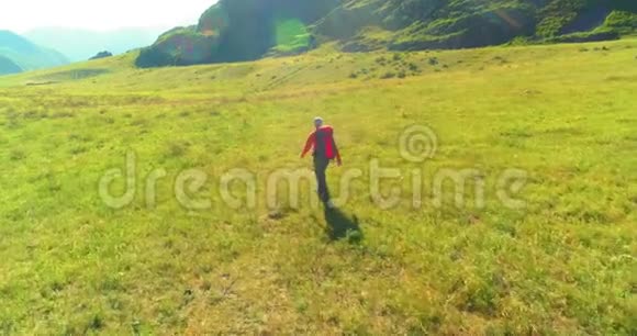 飞行背包徒步旅行游客走过青山野夏日的乡村山谷视频的预览图