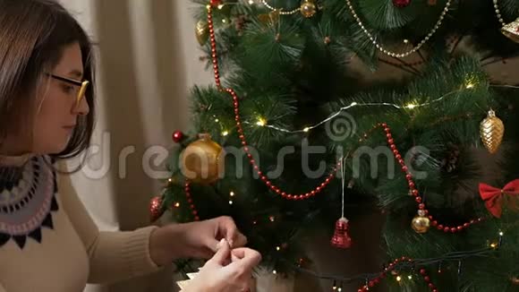 漂亮的金发女郎用装饰圣诞树视频的预览图