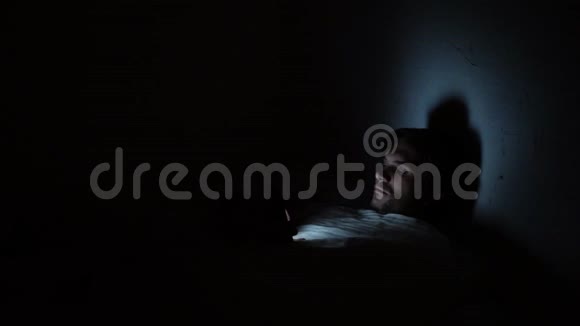 晚上躺在床上的年轻人使用智能手机社交网络和互联网滚动视频的预览图
