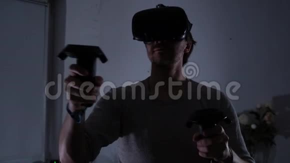 年轻的男性极客正在家里玩虚拟现实游戏一间黑暗的房间视频的预览图