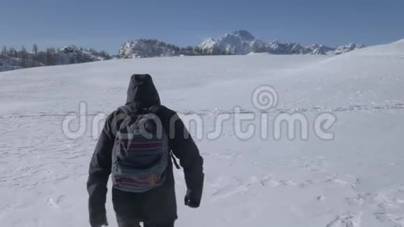 一个徒步旅行者在雪地里行走的轨道射击视频的预览图