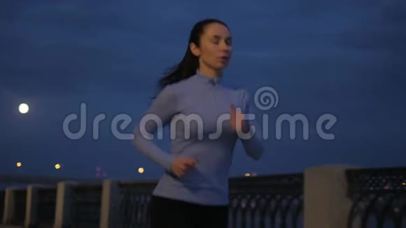 晚上在月光下慢跑1一个小女孩在夜里穿过荒无人烟的街道视频的预览图