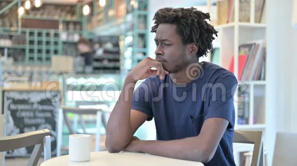 在咖啡馆里思考的非洲男人视频的预览图