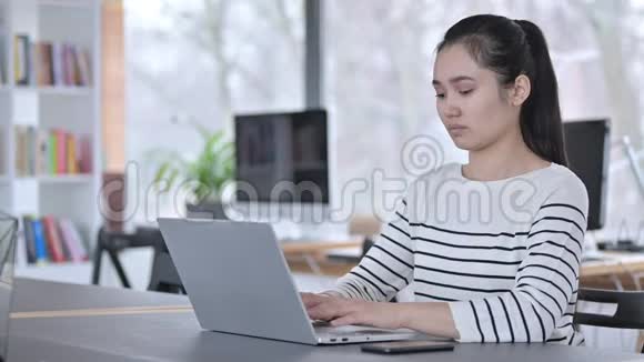 迷人的年轻亚洲女性关闭笔记本电脑视频的预览图