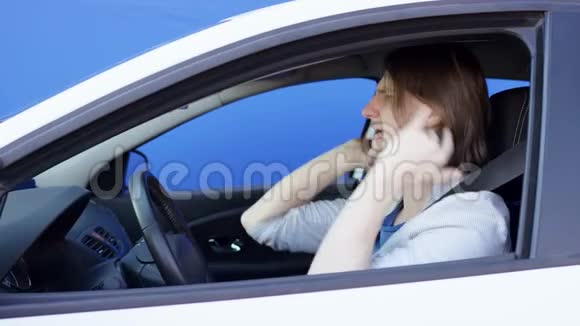 穿着夹克和T恤的布鲁内特男子正在开车时跳舞他在喊叫挥舞着双手笑着视频的预览图