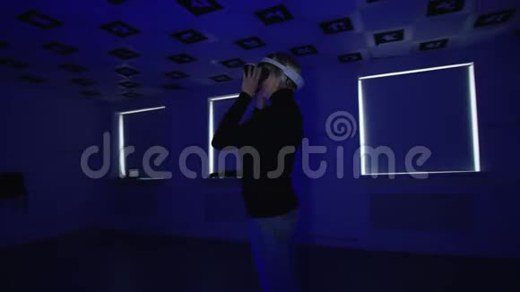一位戴着虚拟现实耳机的年轻女子正在把它摘下来戴着它然后又在空的地方把它摘下来视频的预览图