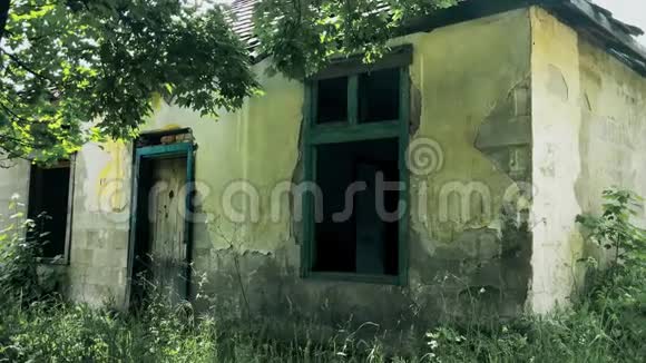 一座被废弃和毁坏的老房子在树间的山上视频的预览图