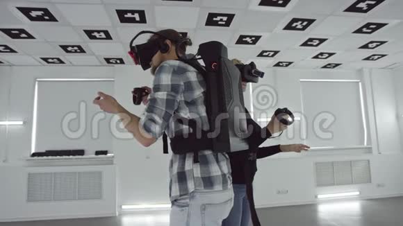追踪一个年轻男女在虚拟现实中背靠背的360度镜头瞄准视频的预览图