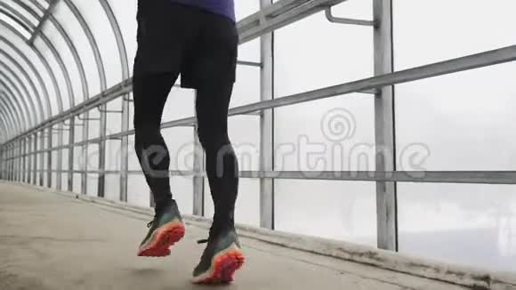 跑步男子在运动服锻炼前三项全能冲刺玻璃隧道视频的预览图