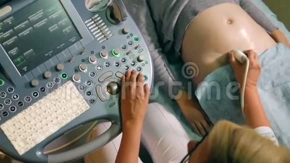 超声检查时控制面板和妇女胃的俯视图视频的预览图