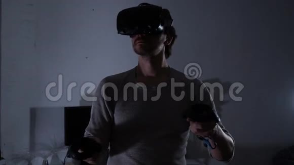 晚上或晚上戴虚拟现实头盔的年轻人使用控制器视频的预览图