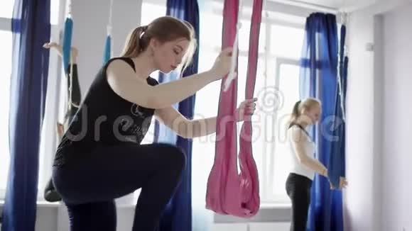 空中瑜伽女性练习伸展运动使用吊床享受健康的健身生活方式锻炼在工作室培训视频的预览图
