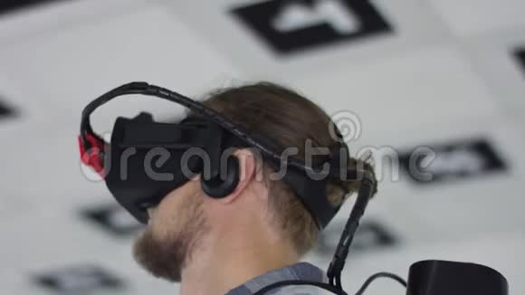 近距离追踪一个戴虚拟现实耳机和玩电子游戏的年轻人360度镜头视频的预览图