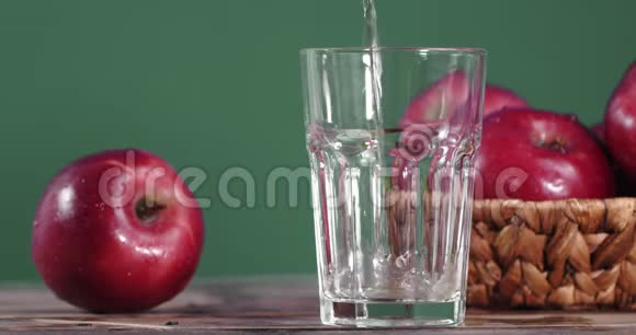把新鲜苹果汁倒入玻璃杯中视频的预览图