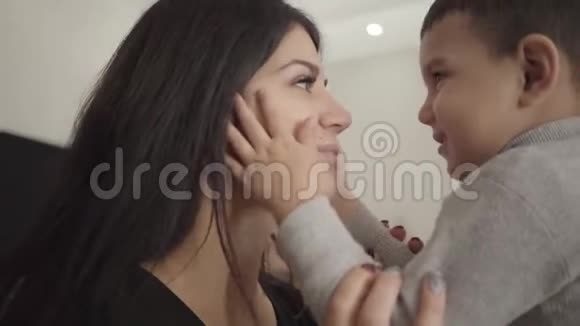 一个微笑的中东女人和男孩揉鼻子的特写快乐的母子互相表达爱视频的预览图