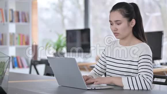 现代办公室中年轻亚洲女性的笔记本电脑使用视频的预览图