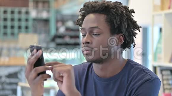 非洲男人在智能手机上庆祝的肖像视频的预览图