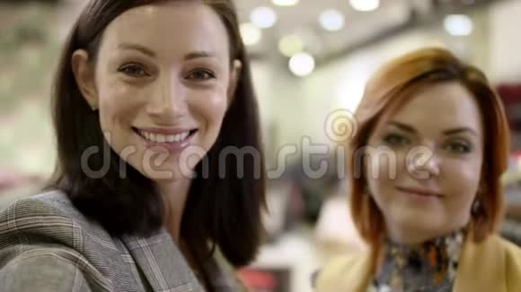 两个幸福的女人在商场的服装店里看着镜头笑了视频的预览图