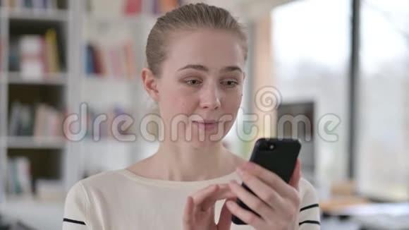 年轻女性在智能手机上庆祝的肖像视频的预览图